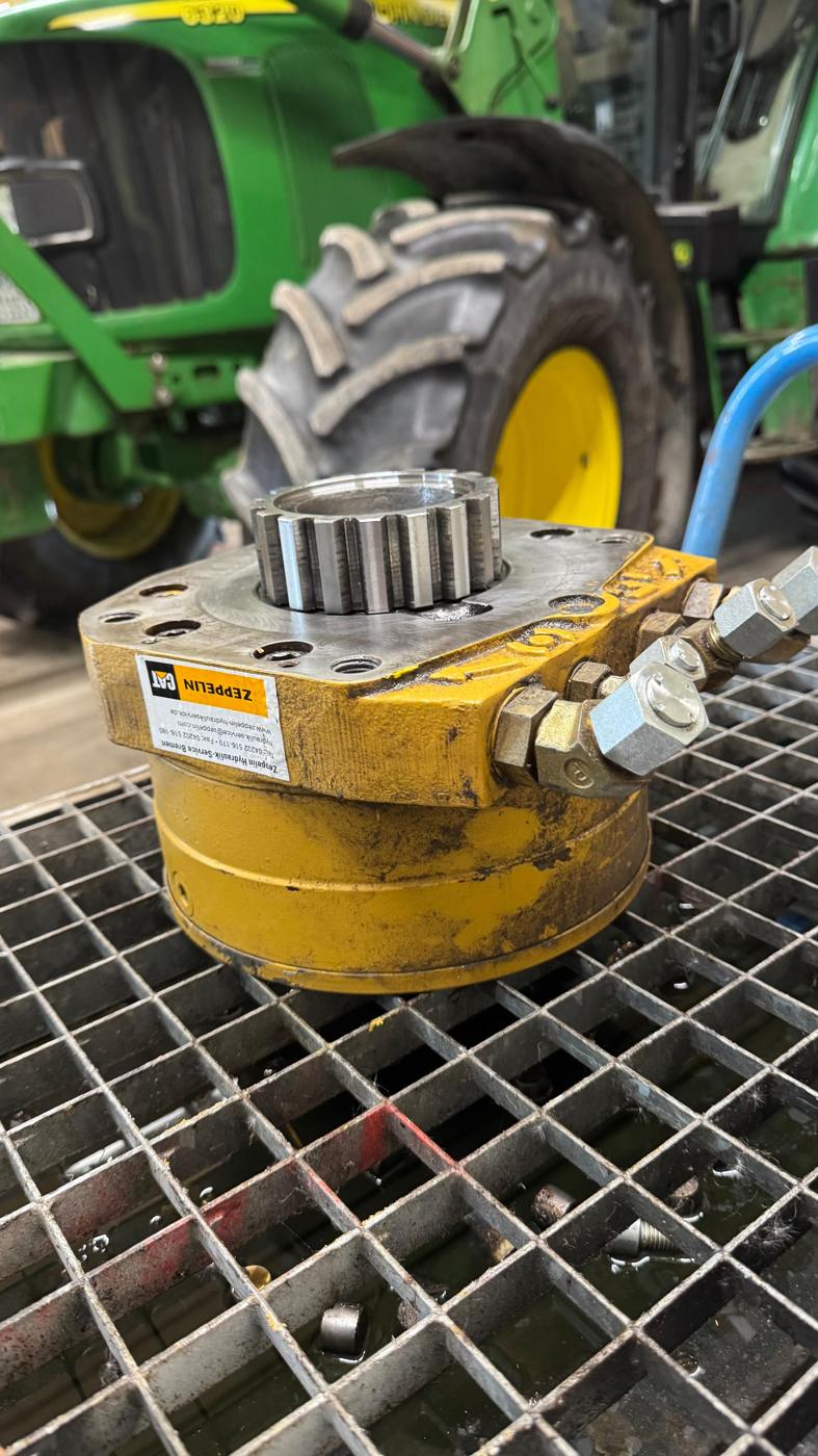 Instandgesetzter Hydraulikmotor vor einem Schlepper