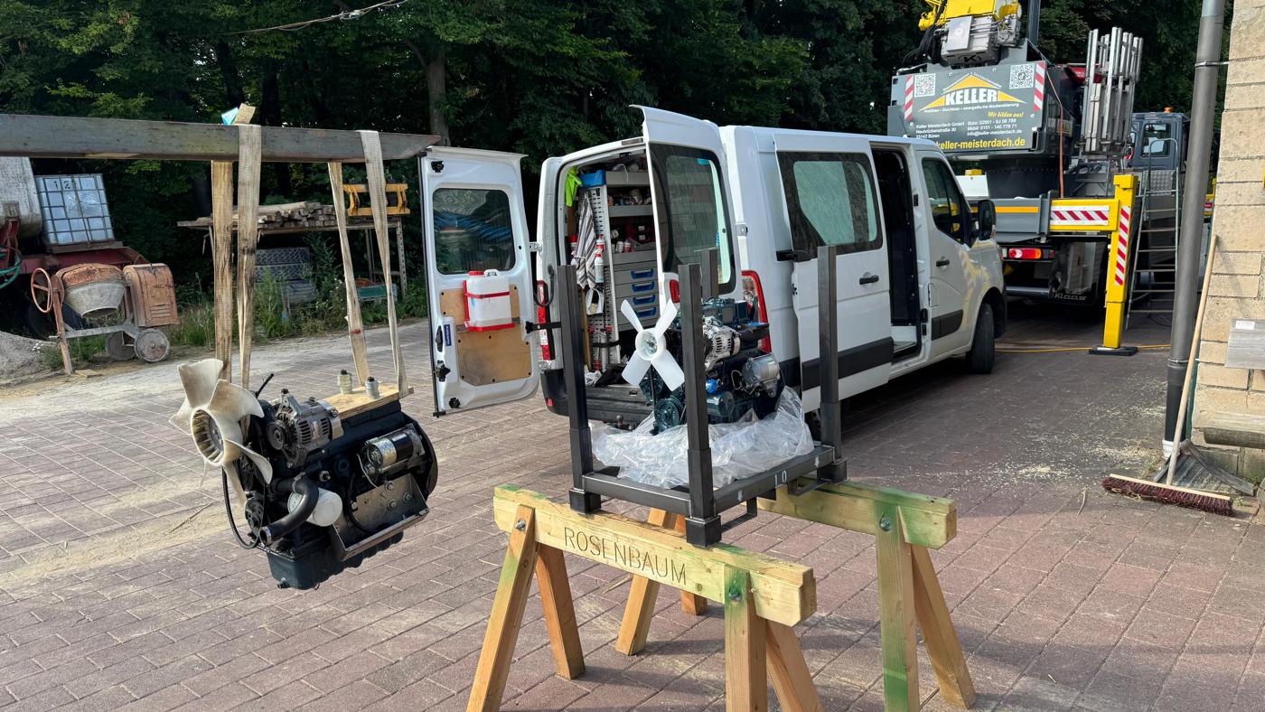 Motor auf Montageböcken vor dem Servicewagen